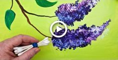 someone is painting purple flowers on a green background with white sticks and blue markers in front of them