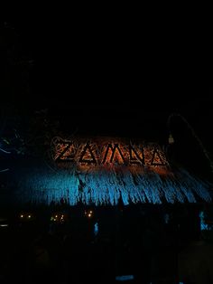 the sign is lit up at night with blue lights