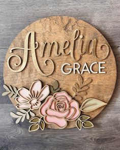 a wooden sign with flowers and leaves on it that says, amelia grace