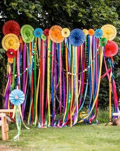 colorful streamers and ribbons are hanging on the wall in front of a picnic table