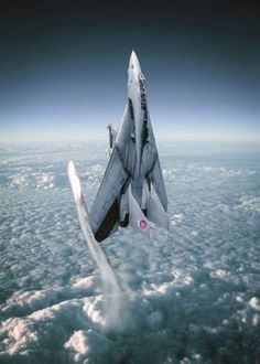 a fighter jet flying through the sky above clouds