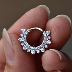 a person is holding an open ring with small flowers on it