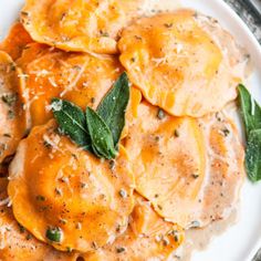 a white plate topped with ravioli and spinach