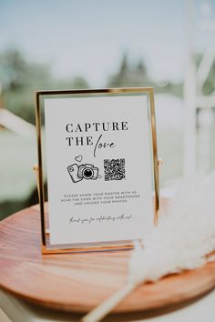 a sign that is on top of a wooden table next to a white feather ornament