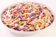 a white bowl filled with coleslaw and carrots on top of a table