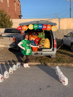 a person standing in the back of a van with stuffed animals on it's trunk