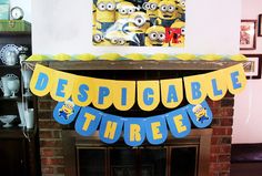 a despiccable three banner hanging from a fireplace mantel in a living room