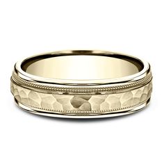 a wedding band with an intricate design in yellow gold