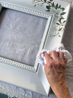 a person wiping the edges of a white frame