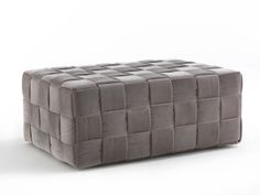 a square footstool made out of grey fabric with squares on the top and bottom