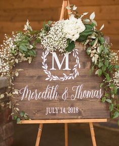 a wooden sign with white flowers and greenery on it that says mr and mrs