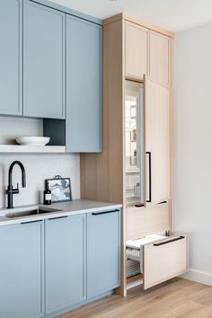 a kitchen with blue cabinets and wooden floors