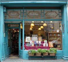 a store front with plants and books on display