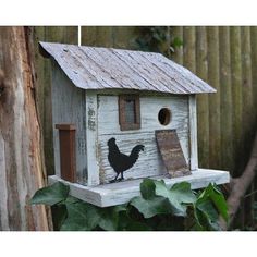 a bird house with a chicken on the roof