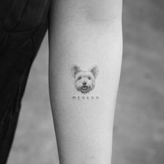 a small dog tattoo on the left inner forearm and leg, with an inscription menon