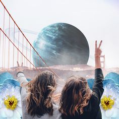 two women are standing in front of the golden gate bridge and looking at the planets