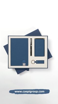 a blue and white box with two pens, scissors and other items in it that are on top of each other