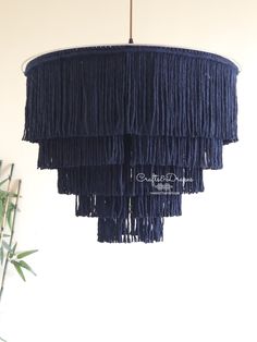 a blue chandelier hanging from a ceiling in a living room with a potted plant