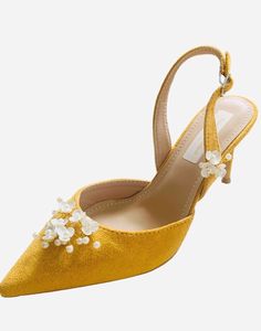 a pair of yellow high heels with flowers on the heel and ankle strap, all in satin fabric