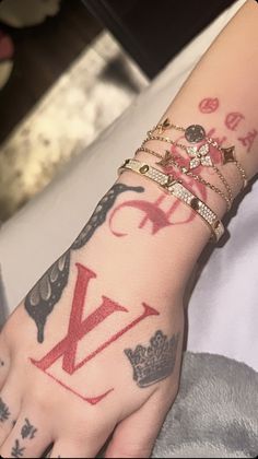 a person with many tattoos on their arm and wrist, holding onto the hand of another person