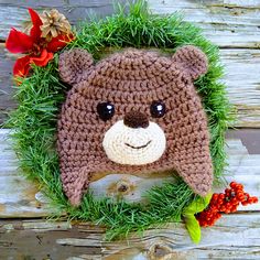 a crocheted teddy bear head hanging from a wreath