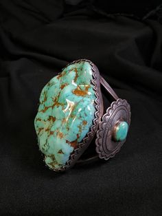 For Sale.  HUGE! Monster! Dry Creek Nevada Turquoise bracelet!  EXTREMELY WELL MADE BRACELET! HEAVY DUTY! SOLID SILVER! WITH SIDE CONCHOS ONE ON EACH SIDE WITH A MATCHING DRY CREEK TURQUOISE  CENTER STONES! THIS IS AN AMAZING SHOW STOPER BRACELET! WITH EXTREMELY RARE HUGE!  DRY CREEK TURQUOISE! Over 600 carats! One of Lander county Nevada's most prolific turquoise mines!  Dry Creek is known for its super hard gem and taking a great polish!  This monster dry creek turquoise stone is  2 - 1/2 inches wide by  3 - 5/8ths inches long and 5/8ths inch plus thick!  The Bracelet opening is 1 - 5/8ths inches!  The Bracelet  inside diameter is 5 - 1/2 inches! This Beautiful Bracelet is Supper well made of heavy thick silver work with incredible bezel work around the turquoise! this bracelet is made f Antique Turquoise Jewelry Gold, Turquoise Cabochon Bracelet, Turquoise Cabochon Round Bracelets, Turquoise Round Cabochon Bracelets, Luxury Handmade Turquoise Bracelet, Luxury Handmade Turquoise Bracelets, Oval Turquoise Collectible Bracelet, Elegant Turquoise Bracelet With Patina, Elegant Turquoise Bracelets With Patina