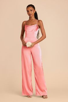 a woman in a pink jumpsuit holding a white flower