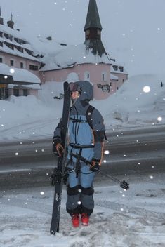 a person holding skis and standing in the snow