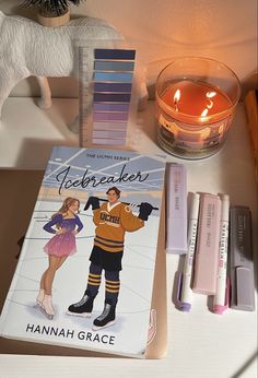 a table topped with books and candles next to a candle holder on top of a counter