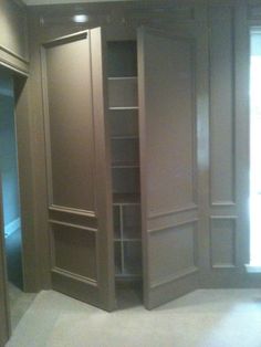 an empty room with wooden closets and glass doors