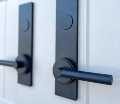 two black handles on a white door