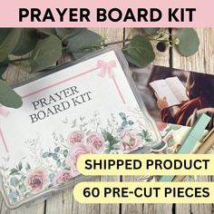 the prayer board kit is laid out on a wooden table with flowers and leaves around it