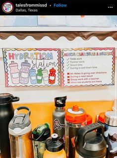 there are many different types of water bottles on the table and one has a sign that says hydration station