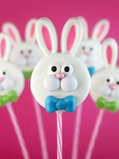 bunny lollipops are sitting on sticks in front of a pink background