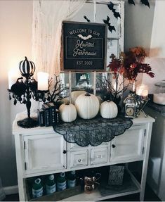 a table topped with lots of white pumpkins next to a sign that says welcome to our beautiful farmhouse