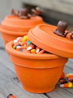 three orange flower pots filled with candy corn