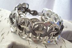 the bracelet is made from metal and has an interlocked design on it's side