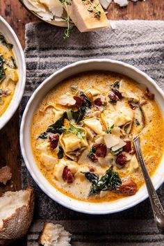 two bowls of soup with spinach, cheese and bread on the side next to each other