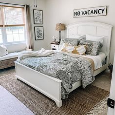 a white bed sitting in a bedroom next to a window