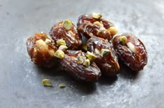 some nuts are sitting on top of a metal surface with seeds sprinkled all over them