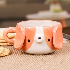 an orange and white dog mug next to crackers