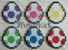 four cross stitch keychains with different designs on them, all in different colors