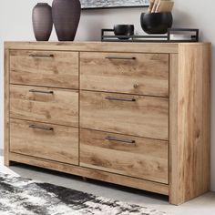 a large wooden dresser with two vases on it's top and an area rug