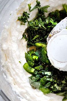 a food processor filled with vegetables on top of a table