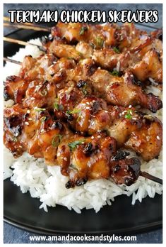 chicken and rice with chopsticks on a black plate