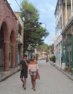 two people are walking down the street together