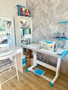 a sewing machine sitting on top of a table next to a white desk and chair