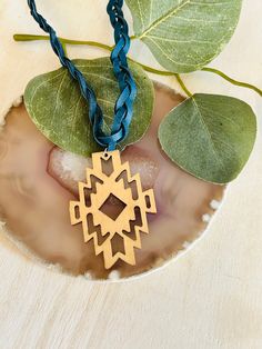 "The adorable blue braided leather and wooden Aztec pendant necklace is made with a 3 braided leather chain and lobster claw connector. Made in the USA. This necklace is the perfect accessory for any women's wardrobe.  This necklace is a great gift for her.  The necklace is a length of 20\" - 22\"" Braided Natural Jewelry As Gift, Natural Braided Jewelry As Gift, Natural Braided Jewelry Gift, Natural Color Braided Jewelry Gift, Southwestern Style Hand Tooled Necklace As Gift, Blue Bohemian Necklaces For Everyday Use, Bohemian Blue Necklaces For Everyday Use, Bohemian Braided Necklace Gift, Bohemian Braided Necklace As Gift