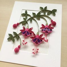 some pink flowers and green leaves on a white card