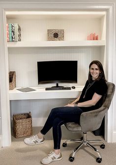 a woman sitting in an office chair next to a desk with a computer on it